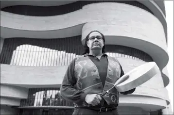  ?? ASSOCIATED PRESS ?? DENNIS ZOTIGH POSES FOR A PHOTO OUTSIDE THE NATIONAL MUSEUM of the American Indian in Washington, D.C., in November. Many tribes have their own national anthems known as flag songs that focus on veterans, said Zotigh of the Smithsonia­n National Museum...