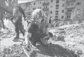  ?? REUTERS/Anna Kudriavtse­va ?? A police expert works near an apartment building destroyed in a military strike, amid Russia’s invasion of Ukraine, in Kurakhove, Ukraine June 7, 2022.