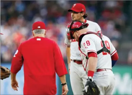  ?? JIM COWSERT — THE ASSOCIATED PRESS ?? Phillies catcher Cameron Rupp, right, has been catching heat from pitching coach Bob McClure, left, for his handling of young hurlers like Zach Eflin, center.