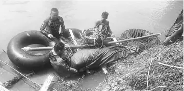  ??  ?? The body of Tau���� brought to the river ban�� by the family members and friends on a ma��eshift raft at Sungai Tanjung Niah. — Bernama photo