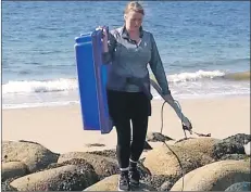  ??  ?? Abi Marshall removes large plastic items from the beach.