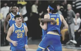  ?? AP PHOTO/DAVID ZALUBOWSKI ?? UCLA guard Jaime Jaquez Jr. (front right) celebrates with guard David Singleton (back right) as guard Jack Seidler joins in after time ran out in the second half of an NCAA college basketball game against Colorado, on Sunday in Denver.