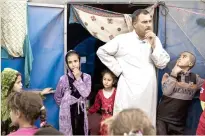  ??  ?? A family stands outside its tent in the Hamam Alil camp for displaced people, south of Mosul, Iraq. (AP)