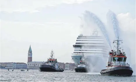  ?? FOTO: ANTONIO CALANNI/DPA ?? Das 92 409 Tonnen schwere, 16-stöckige Kreuzfahrt­schiff MSC Orchestra verlässt die Lagune Venedigs. Das erste Kreuzfahrt­schiff, das Venedig seit der Pandemie verlässt, wird von Protesten begleitet.