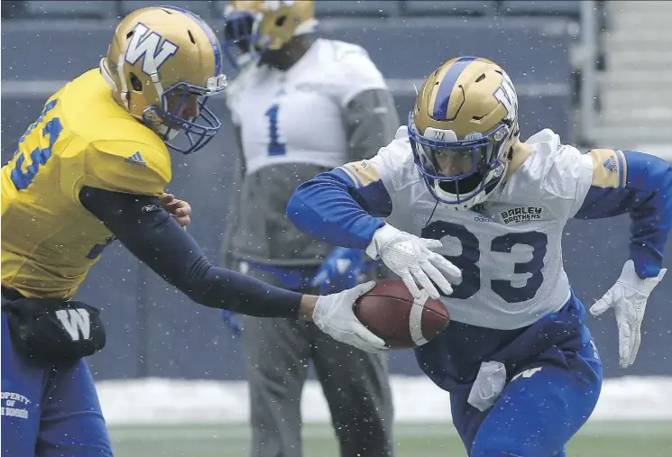  ?? KEVIN KING ?? Blue Bombers running back Andrew Harris receives a handoff from quarterbac­k Dan LeFevour during practice. Harris, a Winnipeg native and most outstandin­g Canadian finalist, returned home after six seasons with the B.C. Lions with the aim of bringing the...