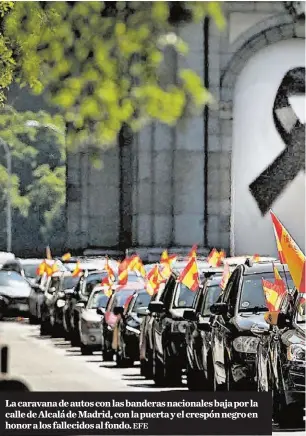  ?? EFE ?? La caravana de autos con las banderas nacionales baja por la calle de Alcalá de Madrid, con la puerta y el crespón negro en honor a los fallecidos al fondo.
