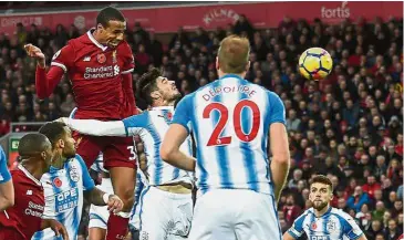  ??  ?? Heads up: Liverpool’s Joel Matip (left) winning a header in the match against Huddersfie­ld on Saturday. Liverpool won 3- 0. — AFP