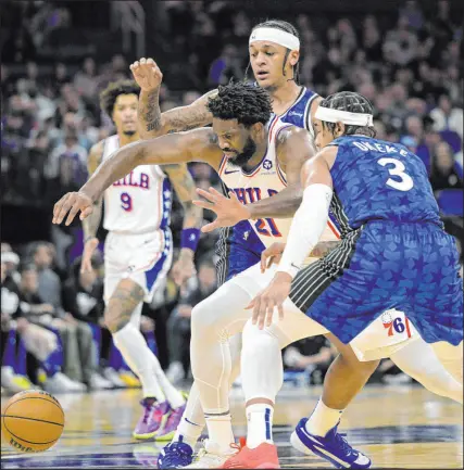  ?? Phelan M. Ebenhack
The Associated Press ?? 76ers star center Joel Embiid, fighting for control of a loose ball with Magic forwards Chuma Okeke (3) and Paolo Banchero, doesn’t know if he will return from knee surgery this season.