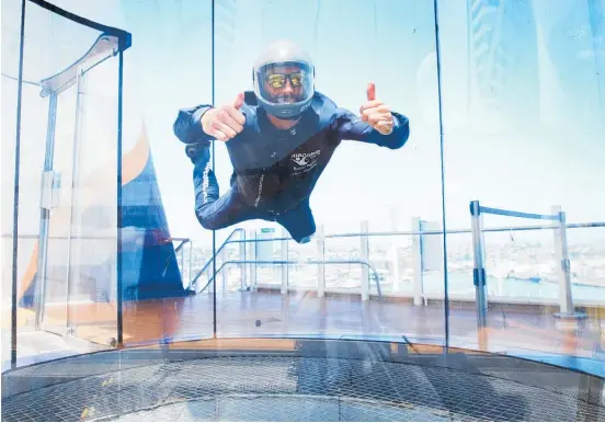  ?? Pictures (main, top left) / Doug Sherring ?? Byron Blane works as an iFly instructor on the 18-level Ovation of the Seas (below) — a role he says lets him meet people from around the world and encounter new cultures at every port.