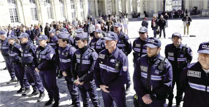  ??  ?? PARIS: French municipal policemen observe a minute of silence yesterday in the courtyard of the town hall in Bordeaux, southweste­rn France, to pay tribute to the police officer who was shot dead by an attacker on the Champs-Elysees the day before in...