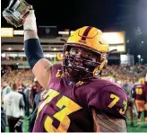  ?? MARK J. REBILAS/USA TODAY SPORTS ?? Arizona State offensive lineman Cohl Cabral (73) celebrates with the trophy after defeating Arizona during the Territoria­l Cup at Sun Devil Stadium.