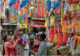  ?? — BIPLAB BANERJEE ?? People buy gulaal from hawkers ahead of Holi in New Delhi on Tuesday.