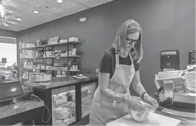  ?? JOEL ANGEL JUAREZ PHOTOS/THE REPUBLIC ?? Shea Cheese co-owner Jenny Zink prepares to cut a slice of Maytag blue cheese at their storefront in Phoenix on Nov. 10.