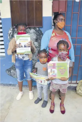  ?? (Photos: Karl Mclarty) ?? Kesha Nunes and her daughters, students at Golden Spring Primary School, arrive yesterday morning to collect textbooks distribute­d by the Ministry of Education.