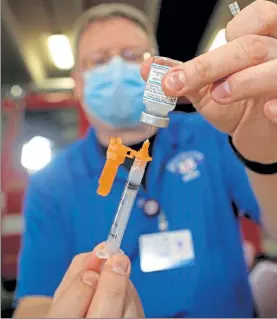  ?? STUART CAHILL / BOSTON HERALD ?? Brewster Paramedic/nurse John Accord preps the Moderna vaccine as the Plymouth Fire Department gets its first doses of the coronaviru­s vaccine on Thursday.