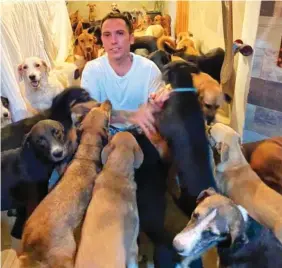  ?? DANIELA ROJAS VIA AP ?? Ricardo Pimentel plays with dogs that he sheltered at his home in Leona Vicario, Mexico, during Hurricane Delta.