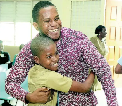  ?? PHOTOS BY IAN ALLEN ?? Deneiro Hines, the 2016 Gleaner’s Children’s Own Spelling Bee parish champion for Clarendon, receives a hug from coach Errol Campbell after winning the competitio­n.