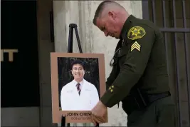  ?? JAE C. HONG — THE ASSOCIATED PRESS ?? Orange County sheriff's Sgt. Scott Steinle displays a photo of Dr. John Cheng, a 52-yearold victim of the shooting Sunday at Geneva Presbyteri­an Church, during a news conference Monday in Santa Ana.