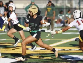  ?? PHOTO BY TRACEY ROMAN ?? Poly's Sydney Santos races downfield as Wilson's Coco Gonzalez pulls her flag during Tuesday's Moore League flag football game. Poly won 32-8to improve to 8-1overall.