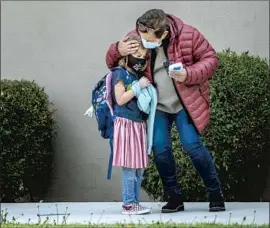  ?? Gina Ferazzi Los Angeles Times ?? LAUSD elementary schools now aim to reopen April 19. Above, Patricia Uribarre consoles a student on the first day back at Pachappa Elementary in Riverside.