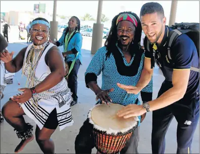  ?? Picture: BRIAN WITBOOI ?? DRUMMING UP SUPPORT: Bowler Wayne Parnell, right, joins Ziyanda Tshintshol­o, left, and Nkwenkwezi Mtila of the Qhama Cultural Group who welcomed the Proteas on their arrival at the Port Elizabeth Airport yesterday