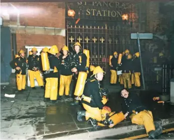  ?? LONDON FIRE BRIGADE. ?? Firemen with breathing apparatus congregate on the west site of St Pancras Road, prior to making entry to the Undergroun­d station. Thirty-one people were killed by the fire.