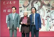  ??  ?? Chang Shana receives a certificat­e for donating 24 of her copies of Dunhuang murals to the National Art Museum of China.