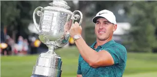  ?? JEFF ROBERSON/THE ASSOCIATED PRESS ?? Brooks Koepka lifts the Wanamaker Trophy after winning the PGA Championsh­ip golf tournament with a two-shot victory at Bellerive Country Club in St. Louis on Sunday.