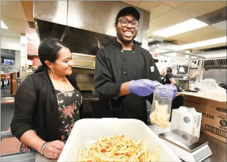  ?? MARK BRETT/Local Journalism Initiative ?? Joshua is pictured working in the Boston Pizza kitchen with his boss Sony Grewal. Joshua is a client of Penticton and District Society of Community Living.