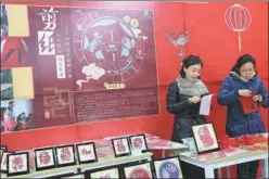  ?? QIU JIER / FOR CHINA DAILY ?? Right: Huang Sihan (right) and her teacher show their paper-cutting skills at the exhibition.