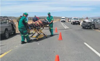  ??  ?? Die beseerde Fernando van Staden word na die ambulans geneem. Hy is met die slag van die botsing uit sy bakkie geslinger.