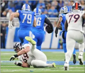  ?? RJ SANGOSTI — THE DENVER POST ?? Lions defensive end Isaiah Buggs runs the ball downfield after recovering a fumble by Broncos quarterbac­k Russell Wilson during the first half of Saturday’s game at Ford Field in Detroit.