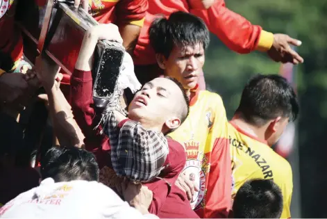  ?? CAMILLE ANTE ?? PANATA Pursigido ang deboto na mahalikan ang krus na pasan ng imahen ng Poong Nazareno nang sumampa siya sa andas sa kasagsagan ng Traslacion sa harap ng Manila City Hall kahapon ng umaga.