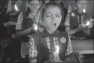  ?? AP/AJIT SOLANKI ?? Students at a school in Ahmadabad, India, hold candles and pray Monday for the boys and soccer coach who have been trapped in a cave in Mae Sai, Thailand.