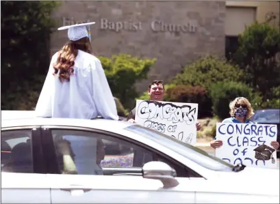  ?? NEWS-SENTINEL FILE PHOTOGRAPH ?? A Liberty High student is congratula­ted during a drive-through graduation ceremony last year at First Baptist Church in Lodi. Lodi Unified School District trustees approved extending reducing graduation requiremen­ts to the Class of 2021.