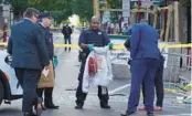  ?? MICHAEL PEREZ/AP ?? Police investigat­ors work the scene Sunday of a fatal overnight shooting on South Street in Philadelph­ia. Gunfire from several shooters killed three people, police said.