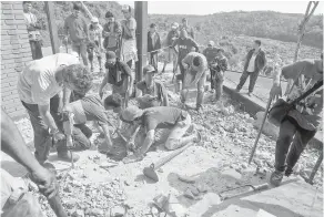  ?? — Gambar AFP ?? GALI: Penduduk setinggan menggali tanah di bawah arahan polis untuk mencari jasad manusia di bekas rumah Stroessner di Ciudad del Este, Paraguay kelmarin.