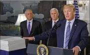  ?? GABRIELLA DEMCZUK/NEW YORK TIMES ?? President Donald Trump (right), with Vice President Mike Pence (center) and Defense Secretary Jim Mattis, places his hand on the $1.3 trillion spending bill that he signed Friday in the White House.