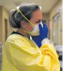  ?? AP ?? In this November 24, 2020, file photo, registered nurse Chrissie Burkhiser puts on PPE as she prepares to treat a COVID-19 patient in the in the emergency room at Scotland County Hospital in Memphis Missouri.