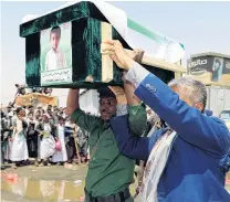  ?? PHOTO: REUTERS ?? A mourner and a policeman carry the coffin of a boy during the funeral of people, mainly children, killed in a Saudiled coalition air strike on a bus in northern Yemen in August.