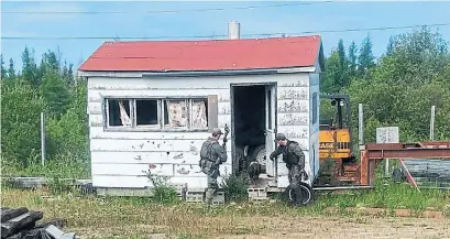  ?? ROYAL CANADIAN MOUNTED POLICE VIA THE ASSOCIATED PRESS ?? RCMP officers canvas homes and buildings in Manitoba as they part of a search for two men suspected of three killings in B.C.