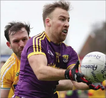  ??  ?? Centre-forward Jonathan Bealin delivers a handpass as Antrim’s Patrick Gallagher closes in.