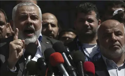  ??  ?? Hamas Supreme Leader Ismail Haniyeh announces the arrest of a suspect in the March shooting death of Mazen Faqha, a top Hamas militant commander in a hastily arranged news conference in front of Fagha’s home in Gaza City on Thursday. Haniyeh refused to identify the suspect, but said that Hamas had determined the gunman, apparently a local Palestinia­n had acted on the orders of Israel and he expected the suspect would face execution. AP PHOTO/ADEL HANA