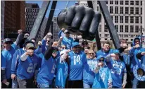  ?? ANDY MORRISON — THE DETROIT NEWS ?? Detroit Lions fans pose for a photo at the Monument to Joe Louis at the NFL Draft Experience in Detroit on Thursday.