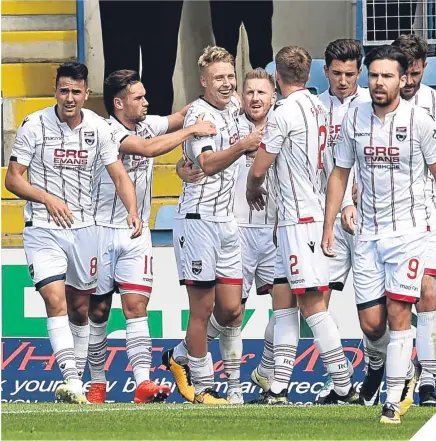  ??  ?? Ross County’s Jamie Lindsay, third from left, celebrates scoring the opening goal.