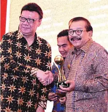  ?? HUMAS PEMPROV JATIM FOR JAWA POS ?? BUAH KERJA KERAS: Menteri Dalam Negeri Tjahjo Kumolo (kiri) menyerahka­n penghargaa­n TOP Pembina BUMD 2018 kepada Gubernur Jawa Timur
Dr H Soekarwo pada acara TOP BUMD 2018 di Jakarta kemarin (3/5).