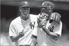  ??  ?? New York’s Giancarlo Stanton watches his solo home run Saturday during the fifth inning against Tampa Bay at Yankee Stadium. Below, winning pitcher Luis Severino shares a laugh with third baseman Miguel Andujar. Severino went eight innings and allowed three hits.