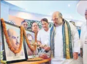  ?? HT FILE PHOTOS ?? Mayor Alok Sharma serves food at the launch of Deendayal Rasoi Yojana in Bhopal and (right) BJP national president Amit Shah pays tributes to Dr Shyama Prasad Mukherjee and Pt Deendayal Upadhyaya in Rohtak.