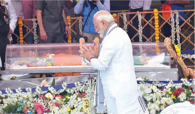  ?? Narendra Modi pays his respects to Manohar Parrikar in Panaji on Monday. Agence France-presse ?? ↑