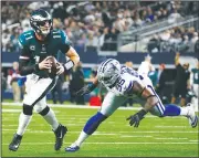  ?? AP/RON JENKINS ?? Philadelph­ia Eagles quarterbac­k Carson Wentz (left) evades pressure from Dallas Cowboys’ David Irving before throwing a pass Sunday in Arlington, Texas.